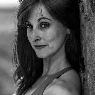 A black and white headshot of a white woman with freckles and shoulder length dark hair, by Christopher Di Nunzio