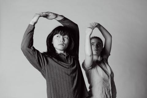 2 students standing with their arms in the air